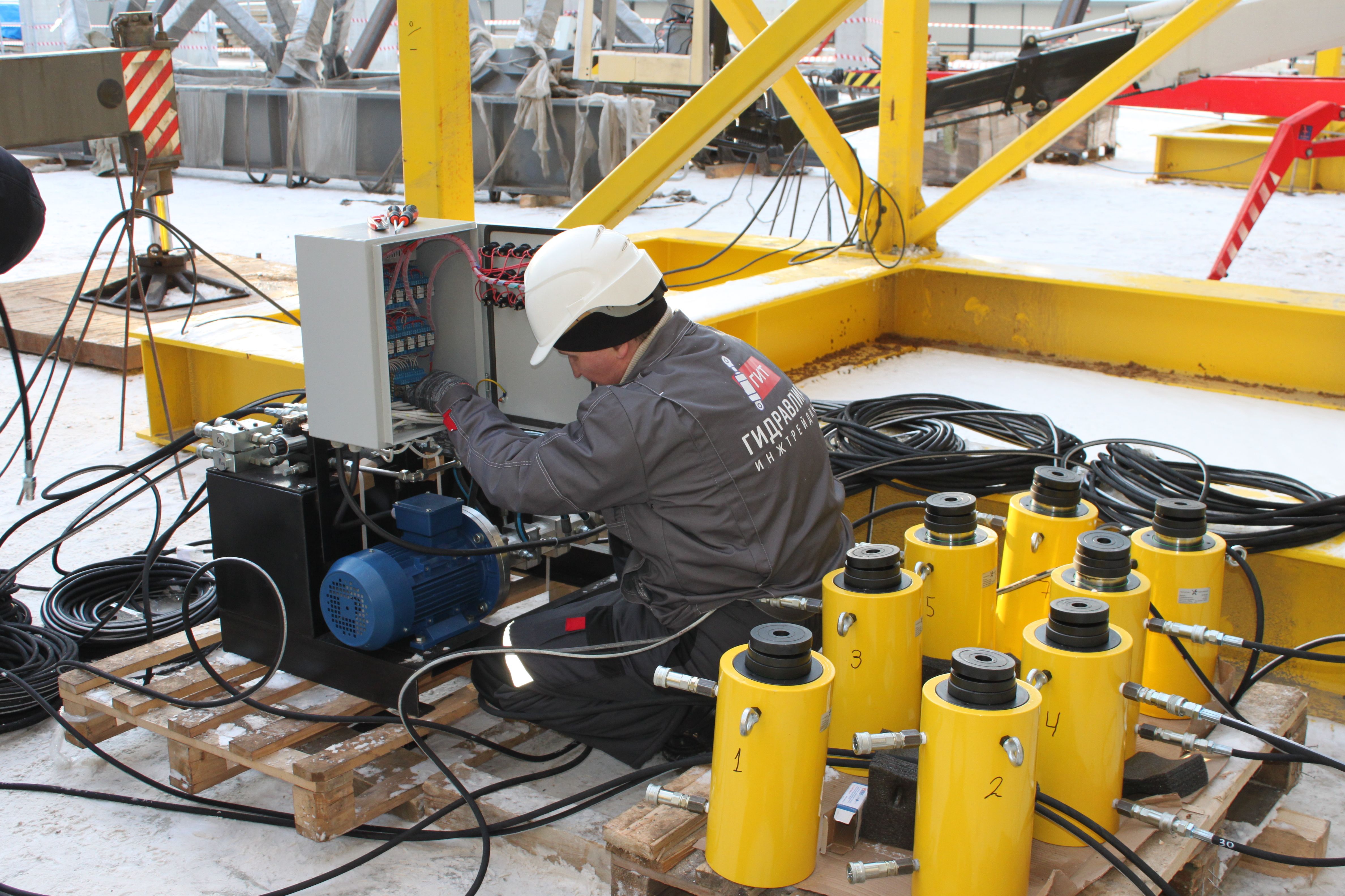 Инженеры выполняют настройку гидравлической системы
